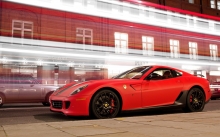 Ночные городские огни на улицах позади красного Ferrari 599